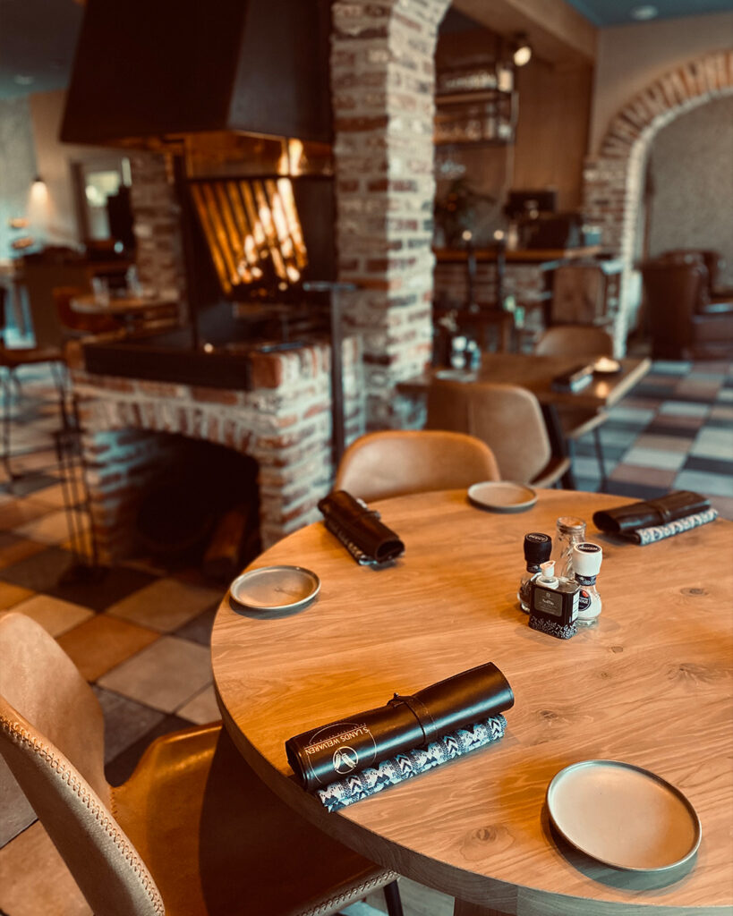 Restauranttafel met op de achtergrond de open haard van Restaurant OEST